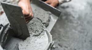 Person mixing mortar in bucket